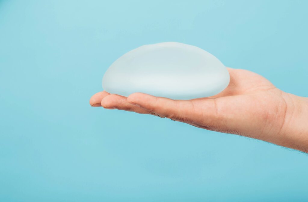 Plastic surgeon holding breast silicone implant crop silicone implant close up augmentation breast size breast surgery